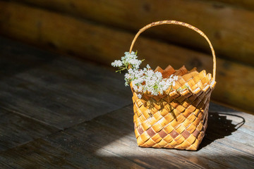 Fototapeta na wymiar Wicker basket with flowers stands on a wooden table