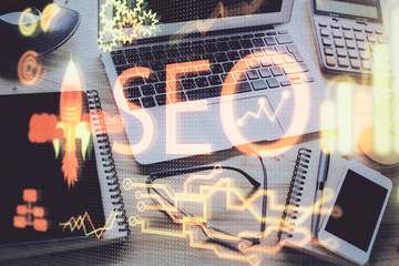 Double exposure of table with computer and seo drawing hologram. Search optimization concept. © peshkova
