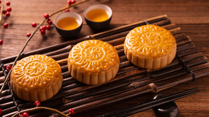 Chinese traditional pastry Moon cake Mooncake with tea cups on bamboo servingwarning tray on wooden...