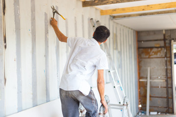Sheathing, insulation of the container. Workers insulate an iron container for a residential building