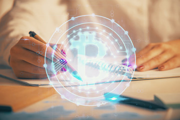 Cryptocurrency hologram over woman's hands writing background. Concept of blockchain. Double exposure