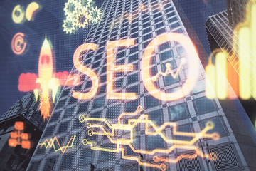SEO hologram on city view with skyscrapers background double exposure. Search optimization concept.