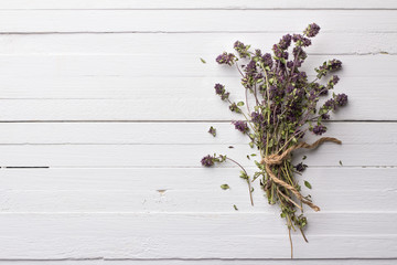 Bunch of dried thyme on a white wooden background, rustic style, top view, free space 