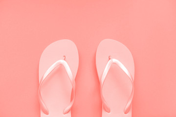 Living coral flip flops on a coral background. Color of the year. Place for text. Copy space for your text. Flat lay, top view. 