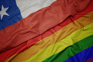waving colorful gay rainbow flag and national flag of chile.