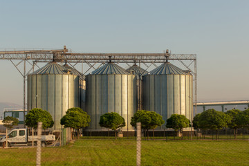 Fototapeta na wymiar Raw material storage tanks,factory landscape gardening, and trees of a dairy food production plant.