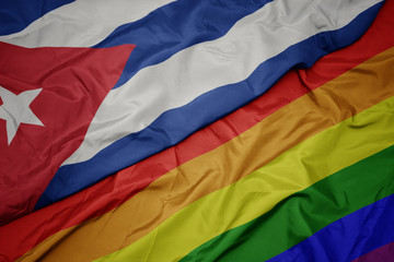 waving colorful gay rainbow flag and national flag of cuba.