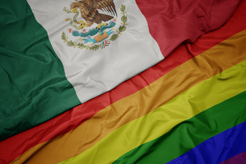 waving colorful gay rainbow flag and national flag of mexico.