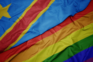 waving colorful gay rainbow flag and national flag of democratic republic of the congo.