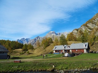 A mountain pasture with its typical houses immersed in the Nature of the Natural Park "Alpe Veglia and Devero", in the Italian Alps, near the town of Domodossola - October 2018.