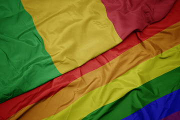 waving colorful gay rainbow flag and national flag of mali.