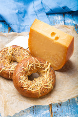 Tasty baked bagels with melted cheese and piece of aged Dutch Gouda cheese