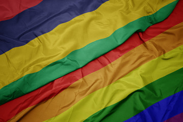 waving colorful gay rainbow flag and national flag of mauritius.