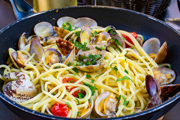 Spaghetti with sea clams, pasta vongole served in cooking pan, tasty italian seafood