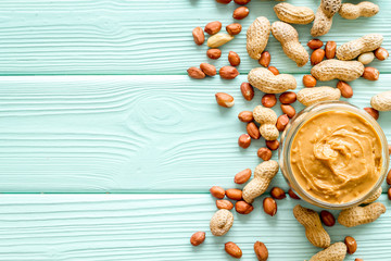 peanut butter for cooking breakfast at home on mint green wooden background top view mock up