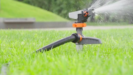  Grass lawn. Watering with sprinkling machine 