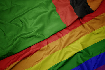 waving colorful gay rainbow flag and national flag of zambia.