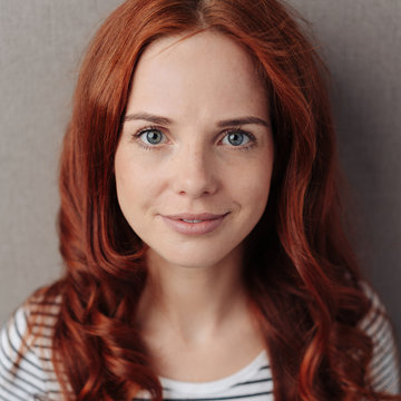 Pretty young redhead woman with a quiet smile