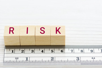 Risk assessment / risk scale analysis and management concept : Words RISK on wood blocks and a ruler, depict uncertainty financial risk or credit profile an investor involved in a trading stock market