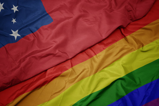 waving colorful gay rainbow flag and national flag of Samoa.