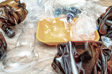 Lot of used plastic, crumpled empty bottles, packets, plastic orange dish, diaper, pollution recycle eco concept background close up selective focus