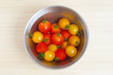水を張ったボウルの中の赤と黄色のカラフルなミニトマト/プチトマト - 野菜・食材素材