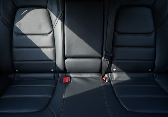 Closeup of a modern car interior with the black leather rear seats