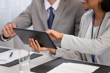 business and technology concept - group of people with tablet pc computer at international conference