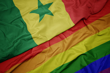 waving colorful gay rainbow flag and national flag of senegal.