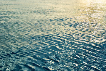 The texture of the water of the sea, ocean with reflecting sun glare.