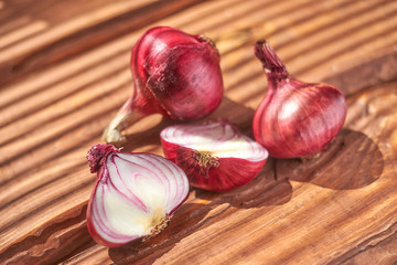 Red onion on a wooden background. Ingredient for salad, cooking.