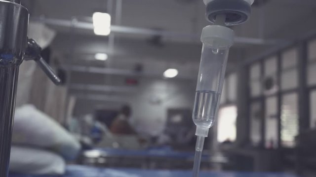 IV infusion. Liquid saline is slowly dripping drops of drugs, medicine or antibiotic therapy and surgery recovery in a hospital or clinic