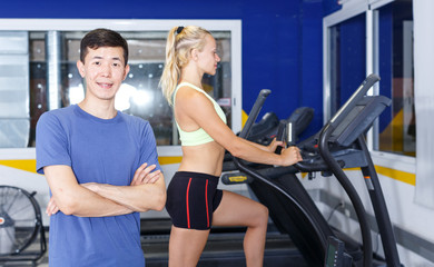 Fototapeta na wymiar Confident trainer posing at gym