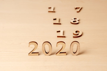 2020 new year change 2019, 2018 and 2017. Wooden numbers on a light table symbolize the change of years