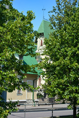 Fototapeta na wymiar House hid behind trees on a city street, Tallinn, Estonia