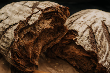 Fresh bread on paper on wooden black background