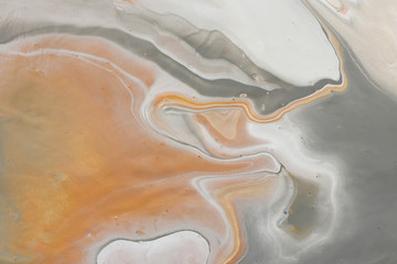 photography of abstract marbleized effect background. black, gray, gold and white creative colors.
