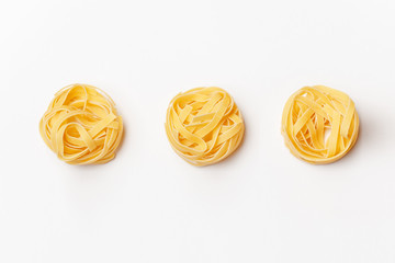 Various uncooked pasta on white background. Top view. Raw pasta with ingredients for cooking. Food...