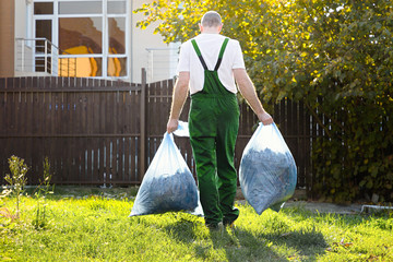 The gardener removes the bags of compost. Green uniform