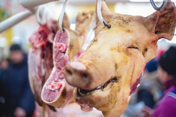 Head of slain pig hanging for sale in the market. selective focus photo from the natural home market with meat horned animals