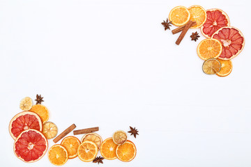 Dried citrus fruits with cinnamon and star anise on white wooden table