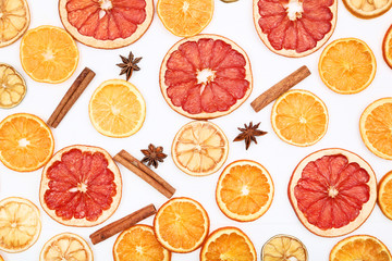 Dried citrus fruits with cinnamon and star anise on white wooden table