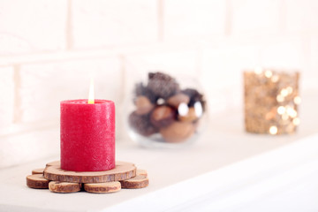 Christmas candle on white fireplace