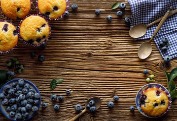 Blueberry muffins and fresh blueberries on a wooden, rustic background with copy space, top view,...