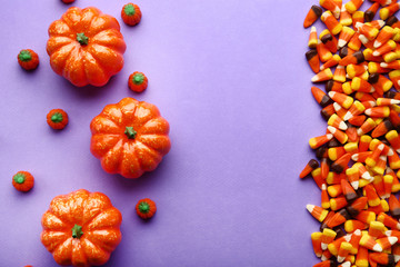 Halloween candy corns and pumpkins on purple background