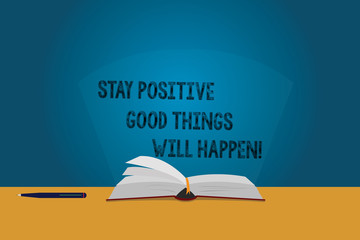 Handwriting text Stay Positive Good Things Will Happen. Concept meaning Keep your motivation inspiration Color Pages of Open Book photo on Table with Pen and Light Beam Glaring