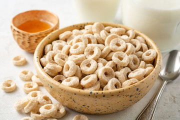 Whole grain cereal rings in bowl on concrete background. Healthy breakfast. Selective focus.