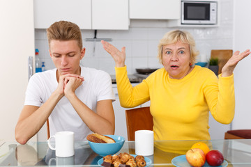 Sad son and unhappy mother quarrelling