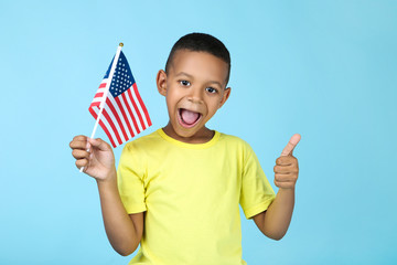 Cute boy with american flag on blue background