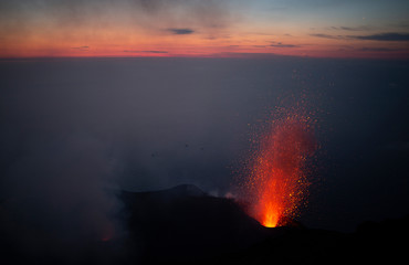 sunset from the summit of active volcano Stromboli with eruptions taking place